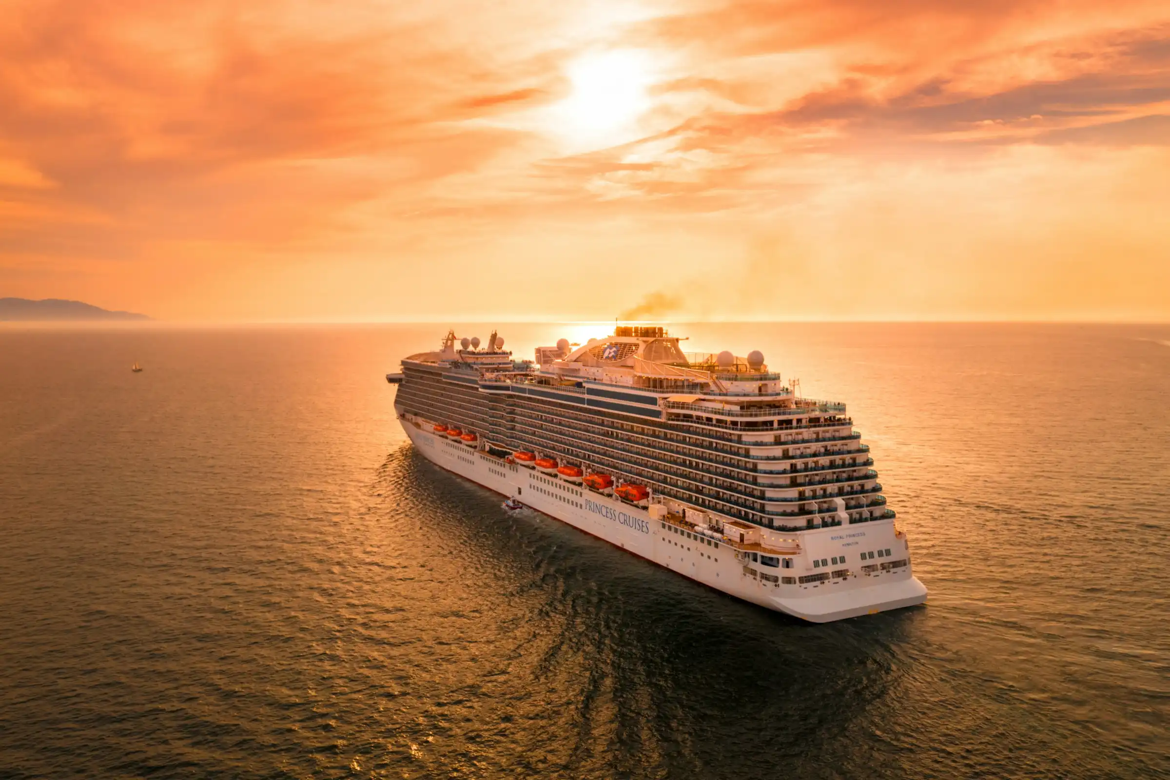 a cruise ship sails off into the sunset